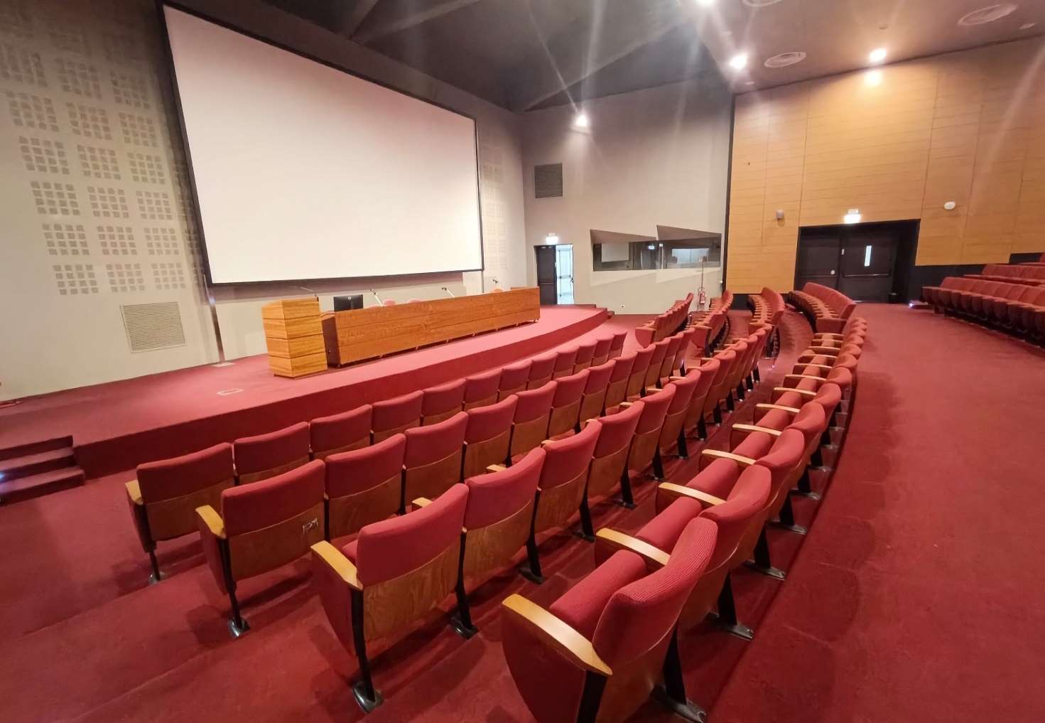View from the audience towards the stage of the Aula Magna CTO showing the projection screen and front rows